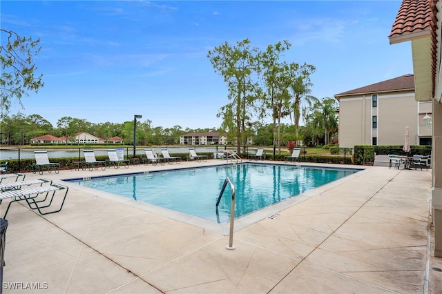 community pool with a patio and fence
