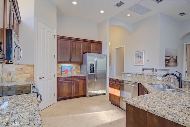 8336 Adelio Ln, Fort Myers, FL 33912 - kitchen featuring stainless steel appliances, arched walkways, a sink, tasteful backsplash, and recessed lighting