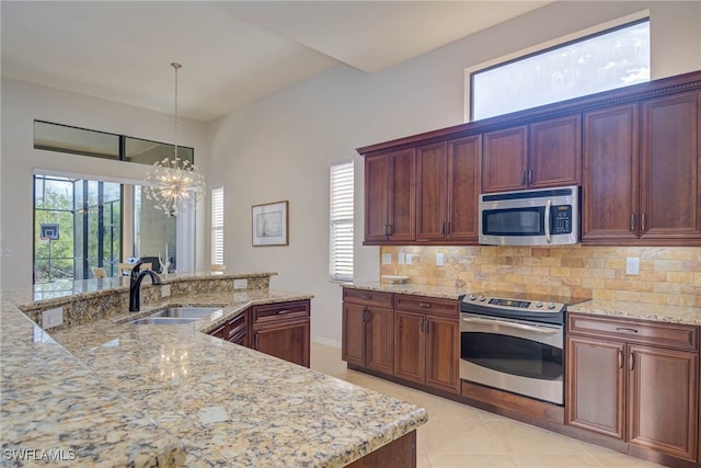 8336 Adelio Ln, Fort Myers, FL 33912 - kitchen with appliances with stainless steel finishes, a sink, backsplash, a chandelier, and pendant lighting