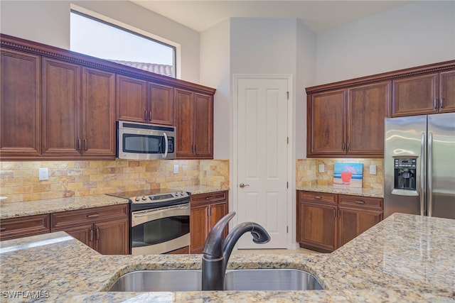8336 Adelio Ln, Fort Myers, FL 33912 - kitchen featuring appliances with stainless steel finishes, a sink, light stone counters, and backsplash