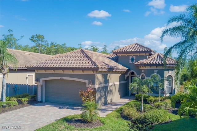8336 Adelio Ln, Fort Myers, FL 33912 - mediterranean / spanish home with a garage, a tiled roof, stucco siding, and driveway