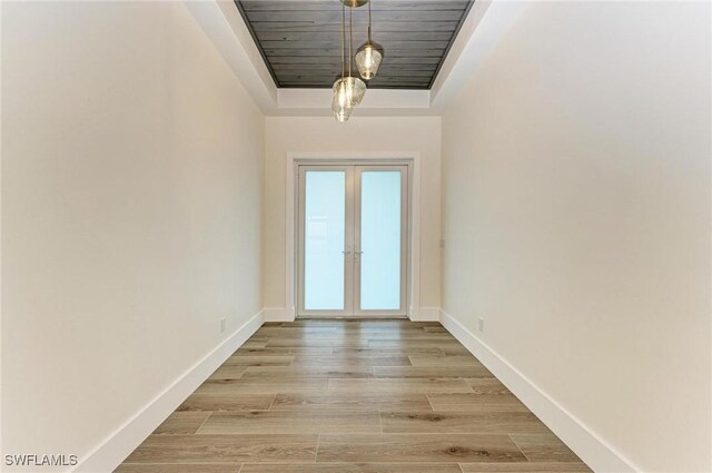 6100 Riverside Dr, Punta Gorda, FL 33982 - entryway with a raised ceiling, baseboards, light wood-type flooring, wood ceiling, and french doors