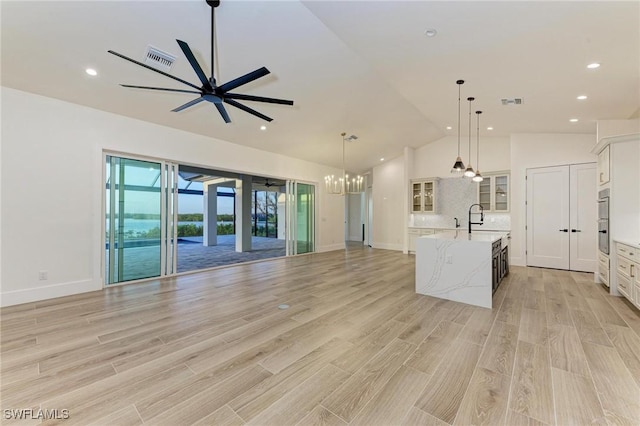 6100 Riverside Dr, Punta Gorda, FL 33982 - kitchen featuring a sink, a center island with sink, open floor plan, a chandelier, and a ceiling fan