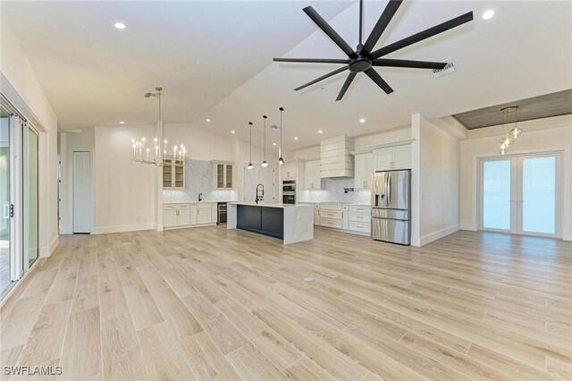 6100 Riverside Dr, Punta Gorda, FL 33982 - kitchen featuring appliances with stainless steel finishes, open floor plan, light countertops, vaulted ceiling, and white cabinets