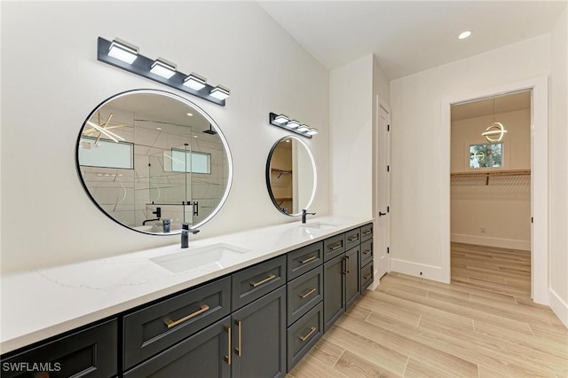 6100 Riverside Dr, Punta Gorda, FL 33982 - bathroom featuring a stall shower, baseboards, double vanity, wood finished floors, and recessed lighting