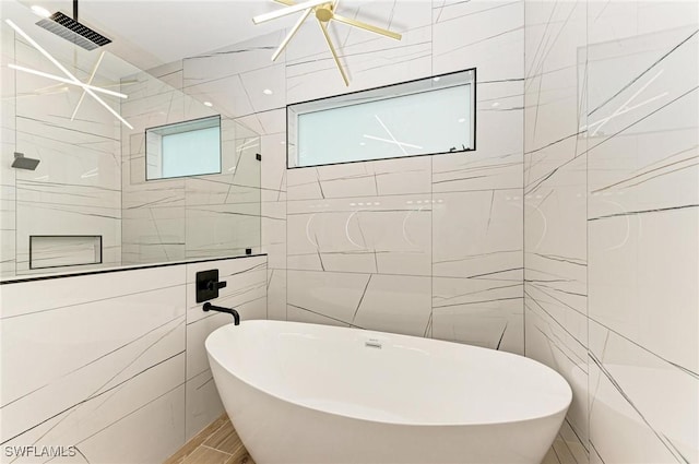 6100 Riverside Dr, Punta Gorda, FL 33982 - bathroom with tile walls, a soaking tub, and a walk in shower