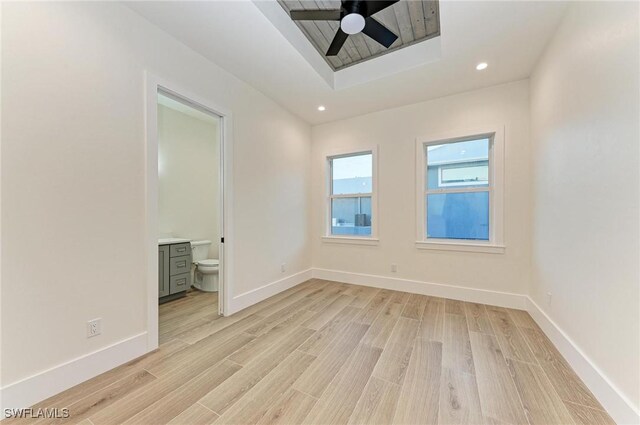 6100 Riverside Dr, Punta Gorda, FL 33982 - spare room with a tray ceiling, a ceiling fan, light wood-style floors, recessed lighting, and baseboards