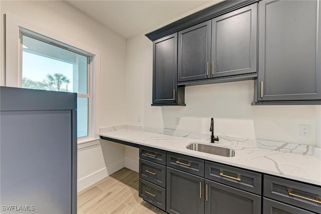 6100 Riverside Dr, Punta Gorda, FL 33982 - kitchen with a sink, light wood-type flooring, light stone counters, and baseboards
