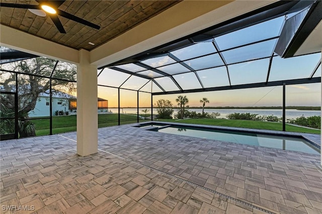 6100 Riverside Dr, Punta Gorda, FL 33982 - patio terrace at dusk featuring a water view, a ceiling fan, a lanai, and an outdoor pool