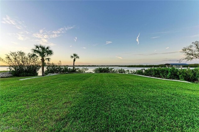 6100 Riverside Dr, Punta Gorda, FL 33982 - yard at dusk featuring a water view and a yard