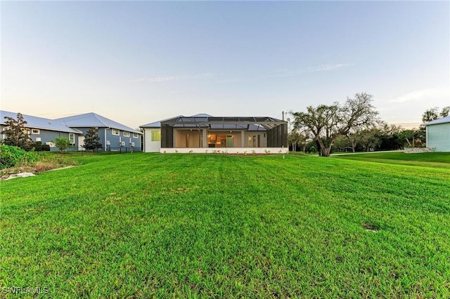 6100 Riverside Dr, Punta Gorda, FL 33982 - back of property featuring a lawn and glass enclosure