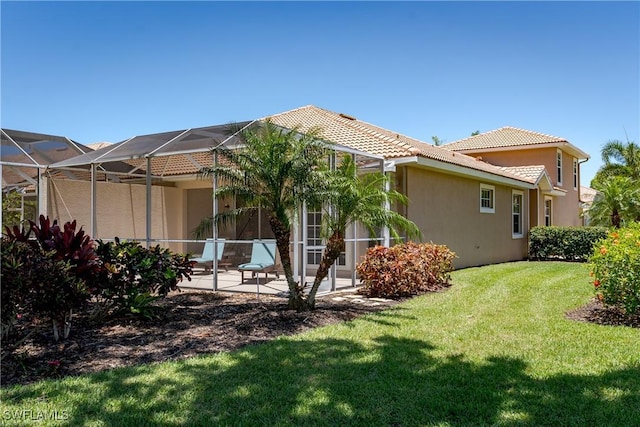 6659 Castlelawn Pl Unit 21, Naples, FL 34113 - rear view of property featuring a tile roof, a patio area, stucco siding, a yard, and glass enclosure