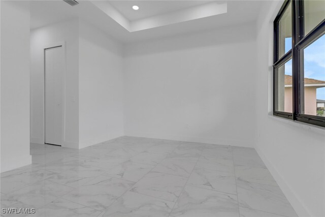 2712 58th St W, Lehigh Acres, FL 33971 - unfurnished room with baseboards, light marble finish flooring, a tray ceiling, and recessed lighting