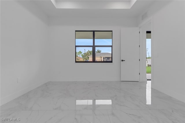 2712 58th St W, Lehigh Acres, FL 33971 - unfurnished room with marble finish floors, a raised ceiling, and baseboards