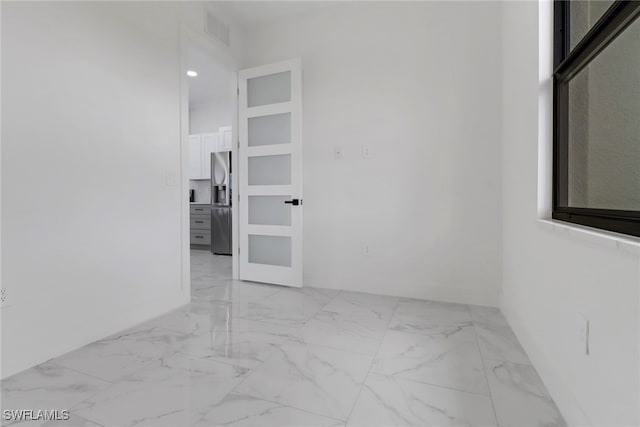 2712 58th St W, Lehigh Acres, FL 33971 - spare room with marble look tile flooring and baseboards