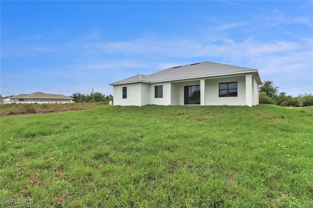 2712 58th St W, Lehigh Acres, FL 33971 - back of house featuring a lawn and stucco siding