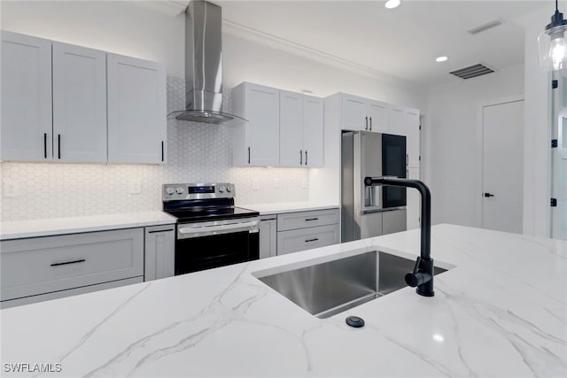 2712 58th St W, Lehigh Acres, FL 33971 - kitchen with appliances with stainless steel finishes, wall chimney exhaust hood, a sink, crown molding, and tasteful backsplash