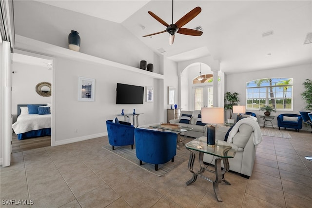 living room featuring ceiling fan, tile patterned flooring, high vaulted ceiling, and decorative columns