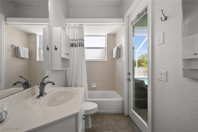 full bathroom featuring toilet, tile patterned floors, a textured wall, vanity, and shower / bathtub combination with curtain