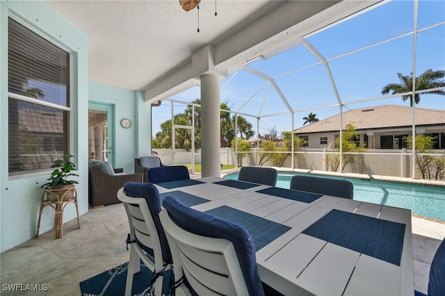 view of patio / terrace with a ceiling fan and glass enclosure