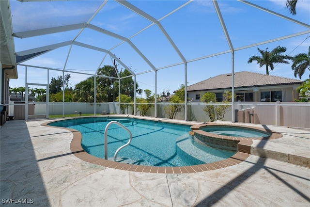 view of swimming pool featuring a patio, a pool with connected hot tub, and a lanai