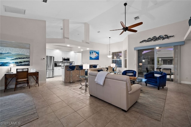living area featuring high vaulted ceiling, a ceiling fan, light tile patterned floors, and baseboards
