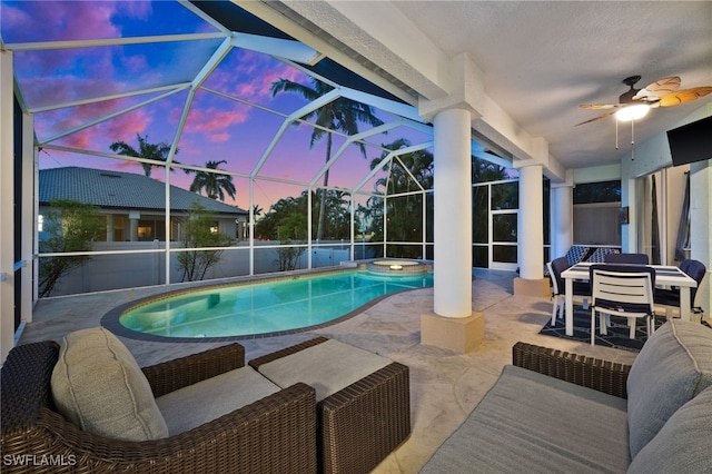 view of swimming pool featuring a patio area, a ceiling fan, a pool with connected hot tub, and a lanai