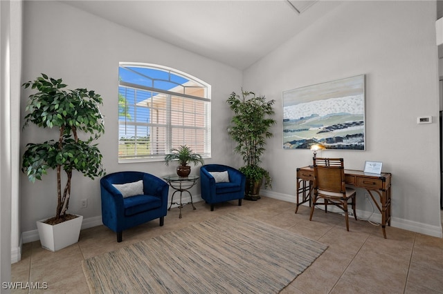 living area featuring lofted ceiling, tile patterned flooring, and baseboards