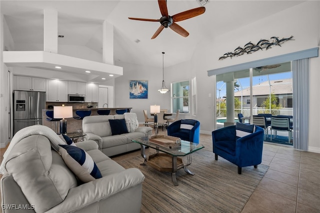 living room featuring a ceiling fan, high vaulted ceiling, baseboards, tile patterned floors, and recessed lighting
