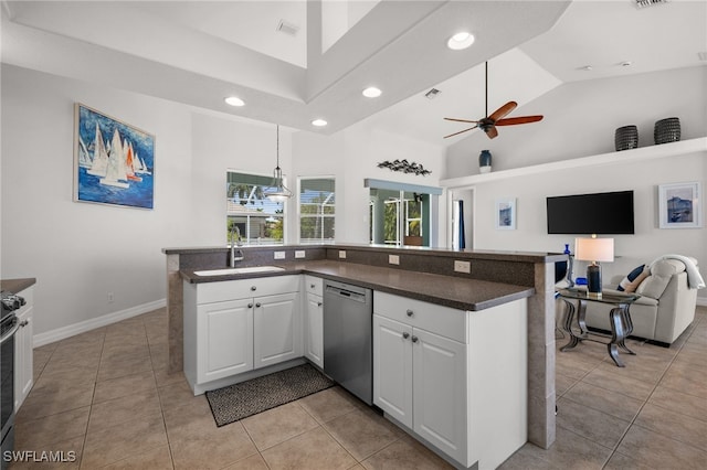 kitchen with stainless steel dishwasher, a sink, open floor plan, recessed lighting, and plenty of natural light