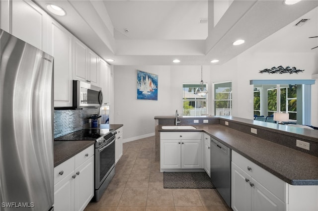 kitchen with appliances with stainless steel finishes, a sink, recessed lighting, dark countertops, and decorative backsplash