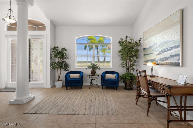 sitting room featuring ornate columns, tile patterned floors, and plenty of natural light