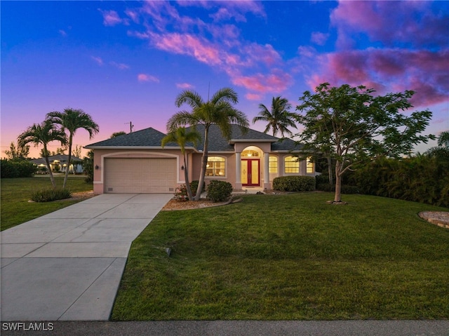 view of front of property featuring stucco siding, a garage, driveway, and a front lawn