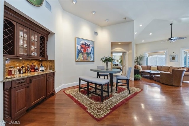 600 Port Side Dr, Naples, FL 34103 - dining room with bar with sink, dark wood-type flooring, high vaulted ceiling, ceiling fan, and baseboards