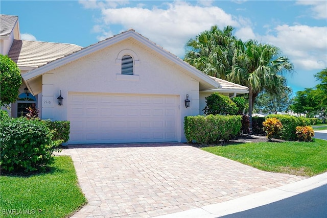 2116 Paget Cir Unit 1, Naples, FL 34112 - single story home featuring stucco siding, decorative driveway, a garage, and a front lawn