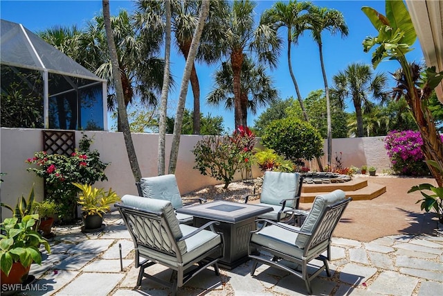 2116 Paget Cir Unit 1, Naples, FL 34112 - view of patio / terrace featuring an outdoor fire pit, a fenced backyard, and glass enclosure