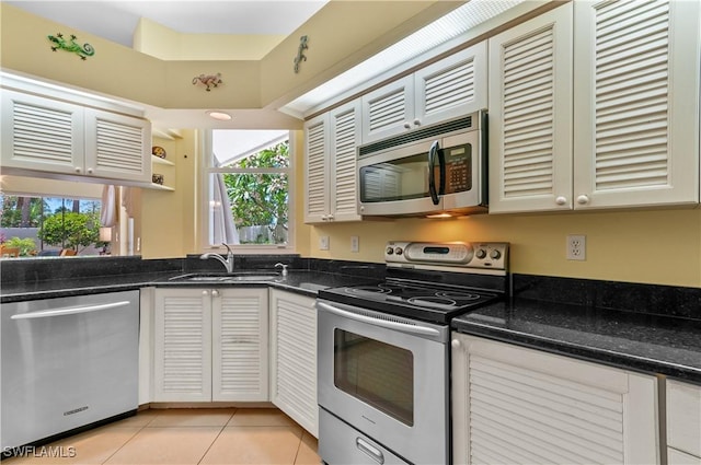 2116 Paget Cir Unit 1, Naples, FL 34112 - kitchen with stainless steel appliances, a sink, light tile patterned floors, dark stone countertops, and open shelves