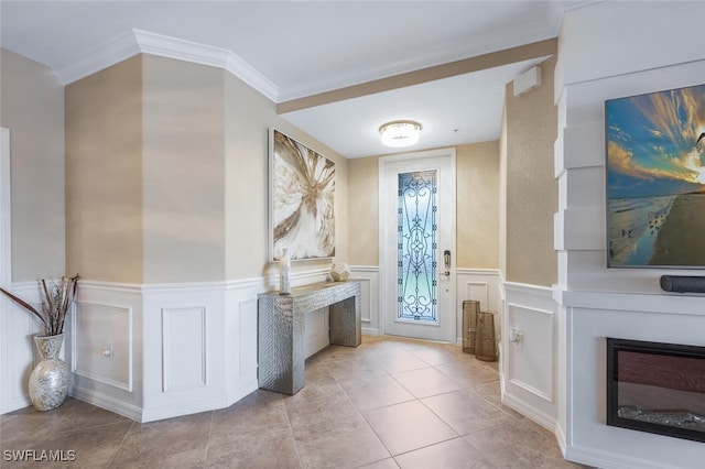 9469 Casoria Ct Unit 101, Naples, FL 34113 - tiled foyer entrance featuring a glass covered fireplace, a decorative wall, wainscoting, and crown molding