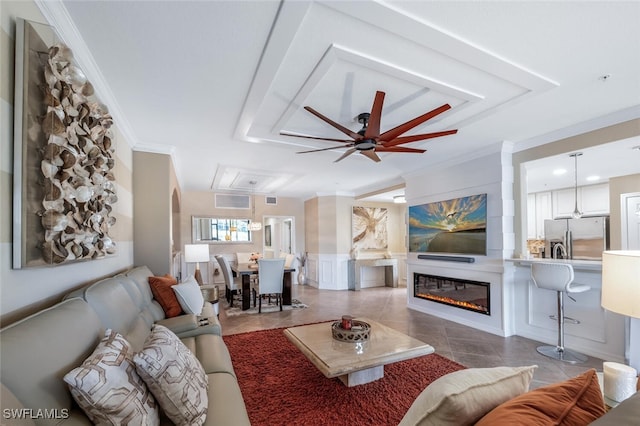 9469 Casoria Ct Unit 101, Naples, FL 34113 - tiled living room with attic access, crown molding, a decorative wall, a wainscoted wall, and a ceiling fan
