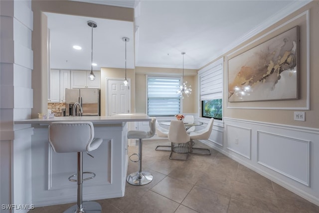 9469 Casoria Ct Unit 101, Naples, FL 34113 - kitchen featuring stainless steel refrigerator with ice dispenser, a kitchen bar, tile patterned flooring, a peninsula, and hanging light fixtures