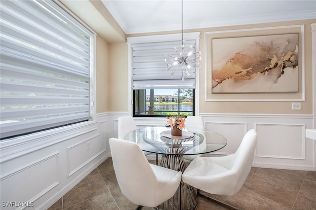 9469 Casoria Ct Unit 101, Naples, FL 34113 - dining area with a chandelier, a decorative wall, wainscoting, tile patterned floors, and ornamental molding