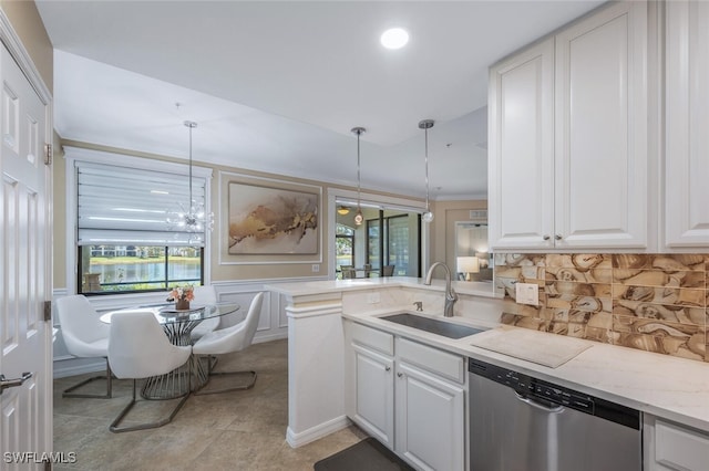 9469 Casoria Ct Unit 101, Naples, FL 34113 - kitchen with dishwasher, a sink, white cabinets, backsplash, and a peninsula