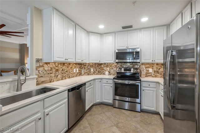 9469 Casoria Ct Unit 101, Naples, FL 34113 - kitchen with appliances with stainless steel finishes, a sink, white cabinetry, decorative backsplash, and recessed lighting