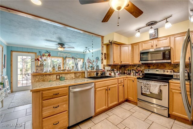 5905 Untermeyer Ct, North Fort Myers, FL 33903 - kitchen with appliances with stainless steel finishes, a sink, a peninsula, a ceiling fan, and tile countertops