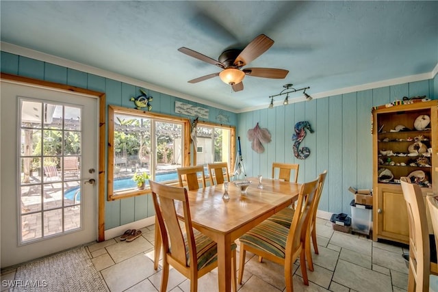 5905 Untermeyer Ct, North Fort Myers, FL 33903 - dining space featuring ceiling fan, crown molding, light tile patterned flooring, and wooden walls