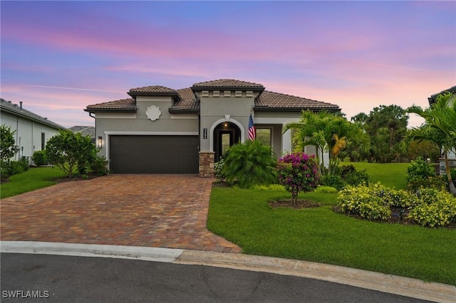 9284 Cormorant Dr, Naples, FL 34120 - mediterranean / spanish home with a yard, stucco siding, an attached garage, decorative driveway, and a tile roof
