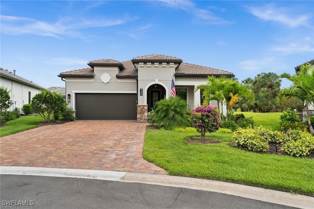 9284 Cormorant Dr, Naples, FL 34120 - mediterranean / spanish-style home with a front lawn, an attached garage, decorative driveway, stucco siding, and a tiled roof