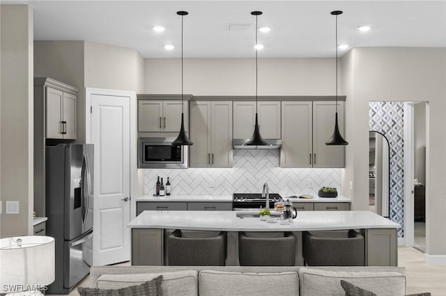 9284 Cormorant Dr, Naples, FL 34120 - kitchen with stainless steel appliances, gray cabinets, light countertops, tasteful backsplash, and recessed lighting