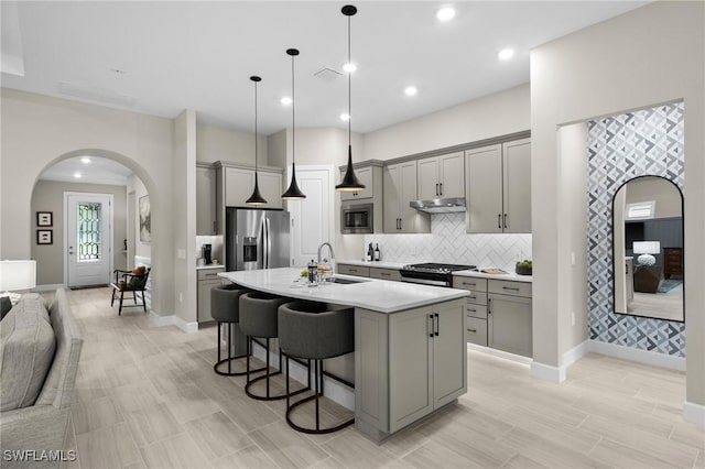 9284 Cormorant Dr, Naples, FL 34120 - kitchen featuring gray cabinetry, appliances with stainless steel finishes, under cabinet range hood, a sink, and recessed lighting