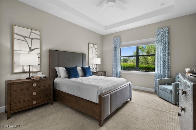 9284 Cormorant Dr, Naples, FL 34120 - bedroom with light colored carpet, baseboards, a tray ceiling, and a ceiling fan